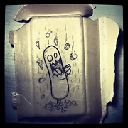 a figure drawn on the back of a styrofoam takeaway container eating falling fast food