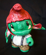  munny toy customized to be a green goblin with a red hat long pointy ears and overalls